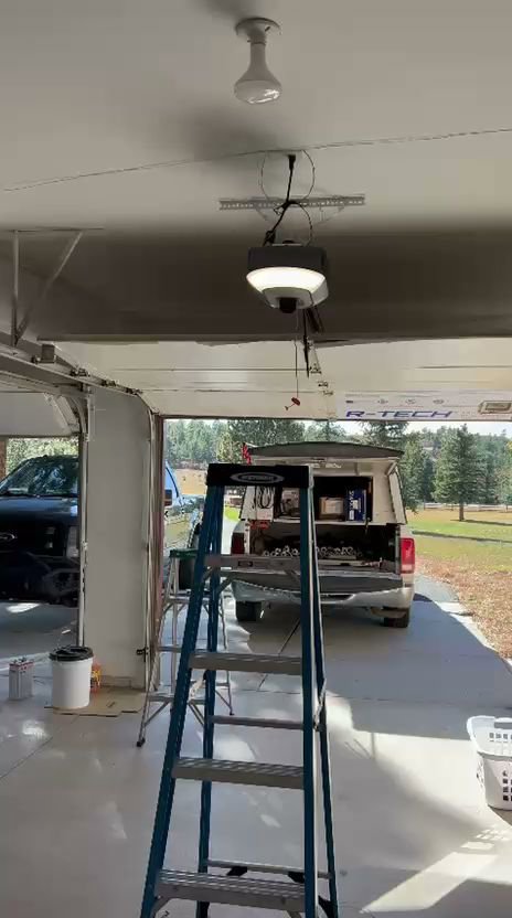 An interior view of a garage with a new garage door opener installed, showing a work site by SS Garage Door Repair in Denver, CO.