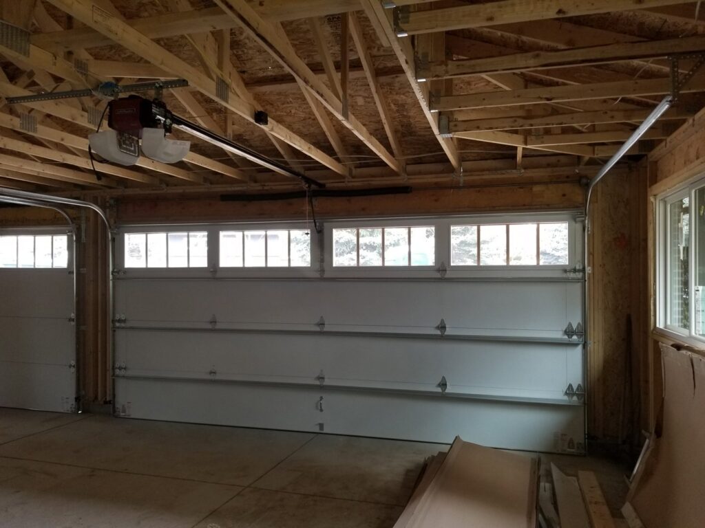 Interior view of a white sectional garage door and opener installation by Colorado Garage Door Pro's in Denver, CO