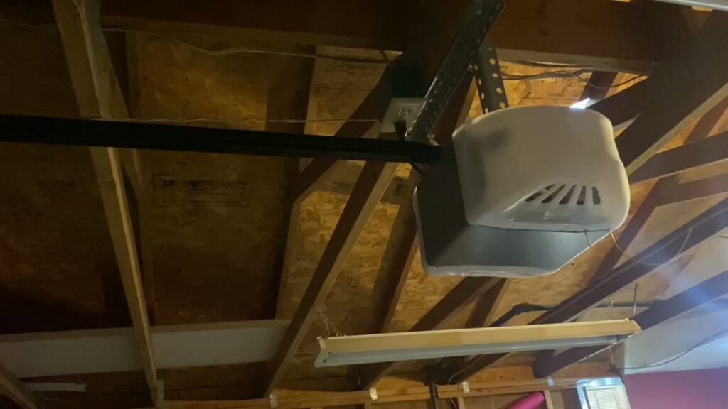 A garage door opener installed on a ceiling with exposed beams by Tucson Garage Door Doc in Tucson, AZ.