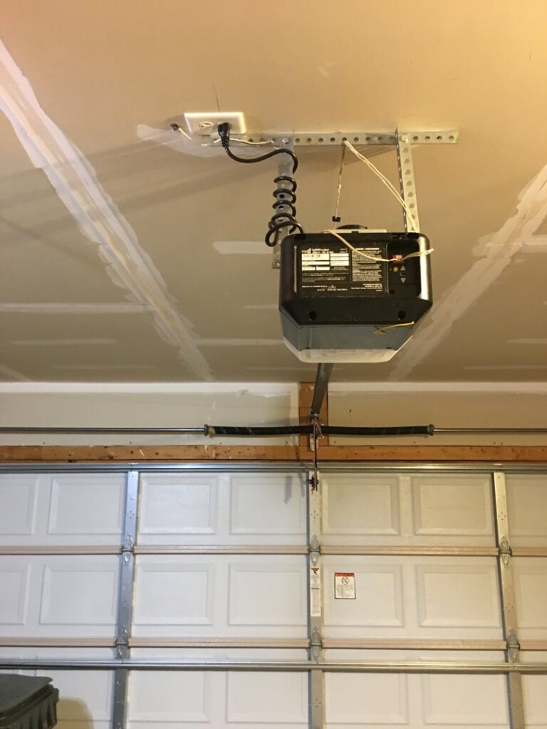 Interior view of a white garage door and an installed overhead garage door opener system by Precision Garage Door of Owensboro Evansville in Owensboro, KY.