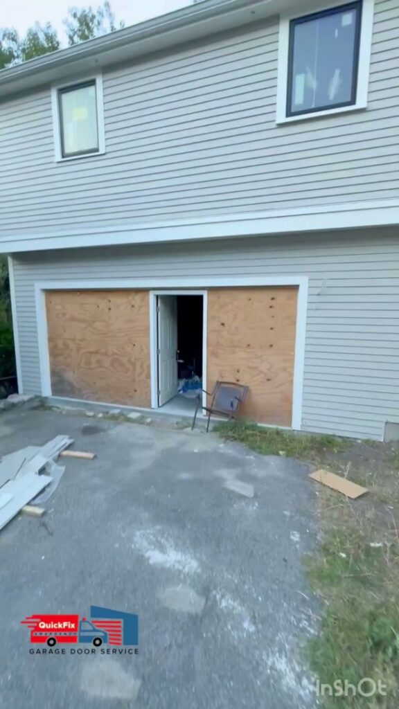 A garage door opening temporarily boarded up with plywood, indicating a repair or new installation project by QuickFix Garage Door Service in Brighton, MA.