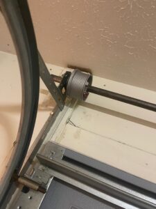 A close-up view of a garage door pulley and cable system, showing components installed by Swift Garage Door in Nashville, TN.