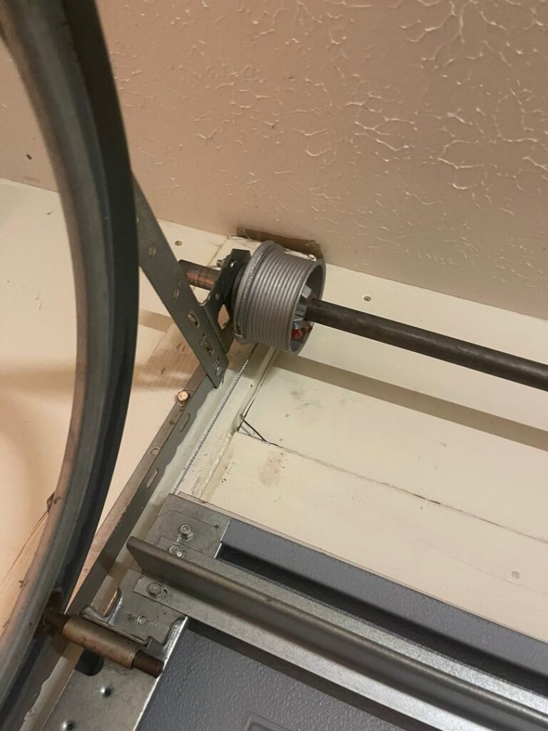 A close-up view of a garage door pulley and cable system, showing components installed by Swift Garage Door in Nashville, TN.