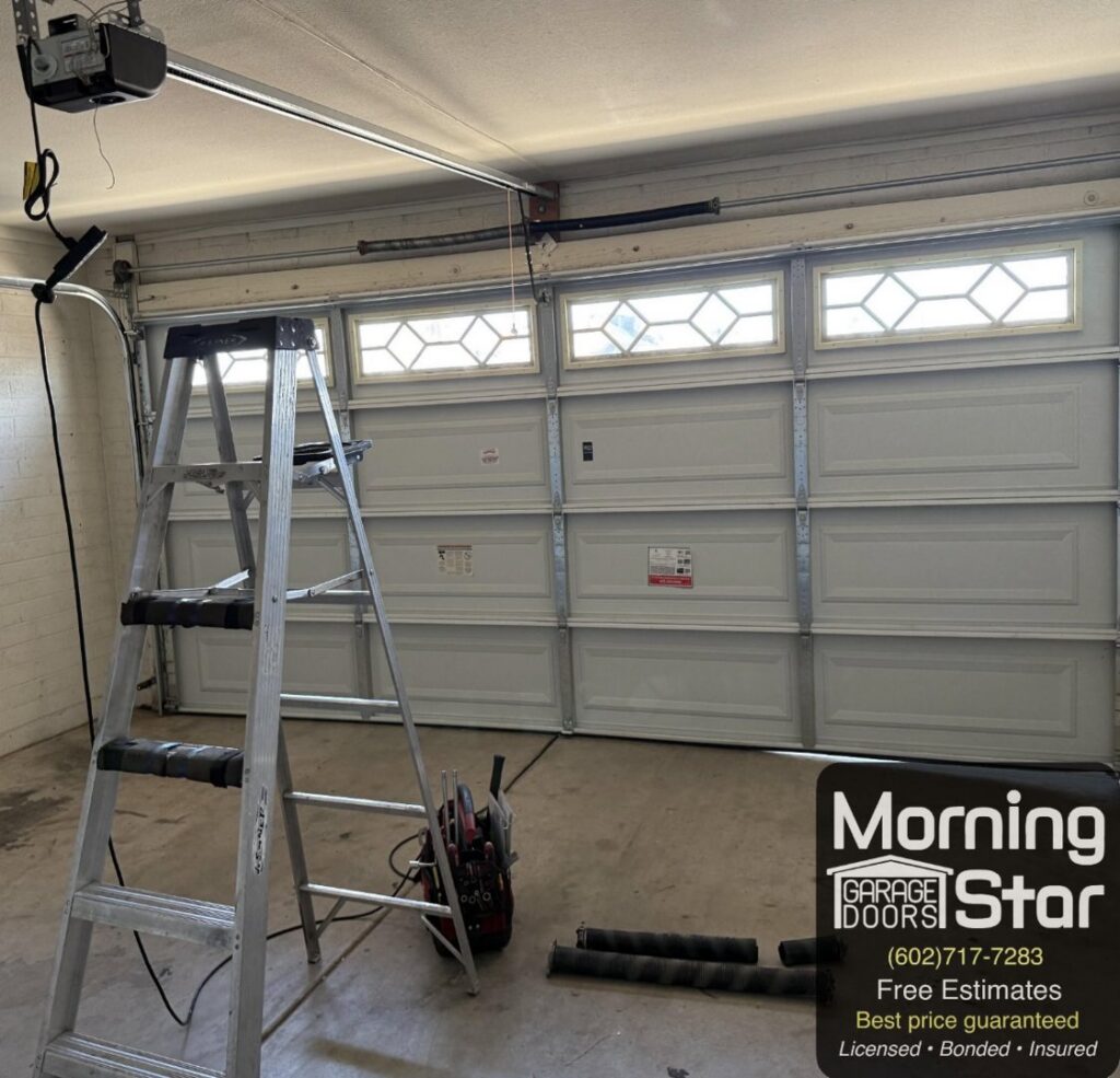 A garage door repair or installation service in progress with a ladder and tools by Morning Star Garage Doors in Phoenix, AZ