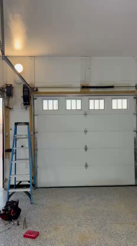A garage door repair work area with a ladder and tools, indicating service by SS Garage Door Repair in Denver, CO.