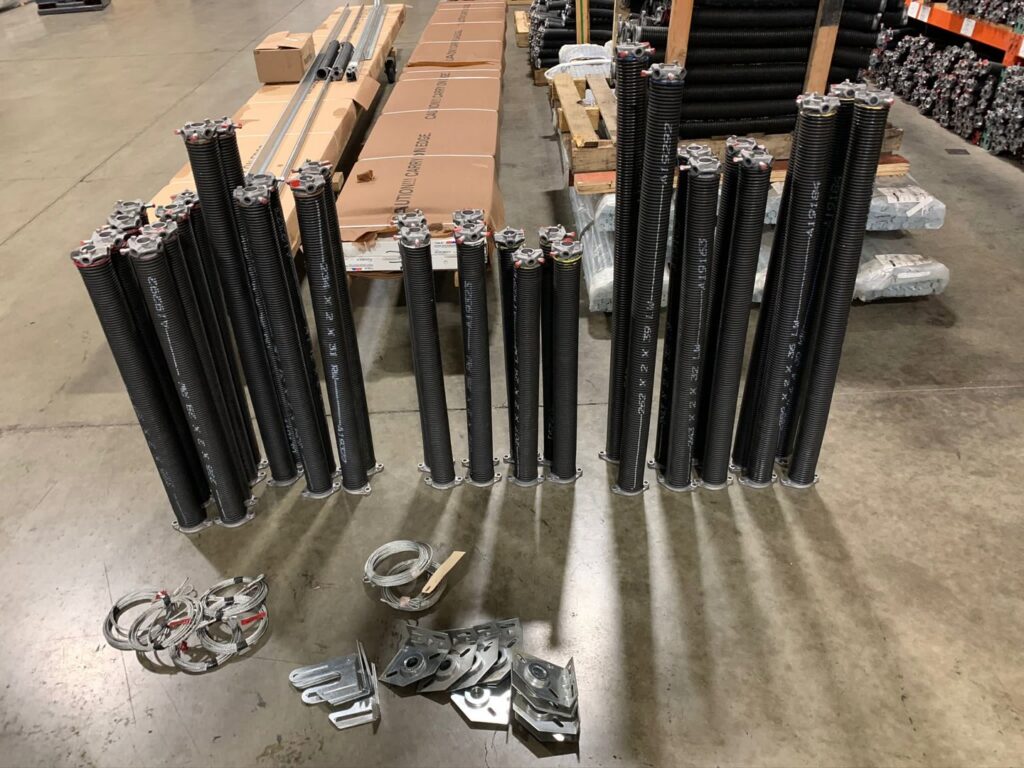 A garage door replacement in progress with new panels on the ground by CHS Garage Repair of Seattle, WA.