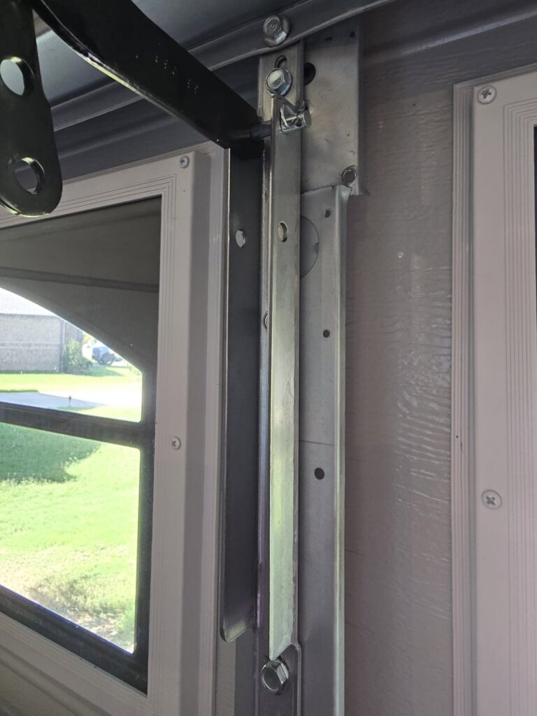 Close-up of a garage door roller and track system being serviced by American Overhead Door in Madison, AL