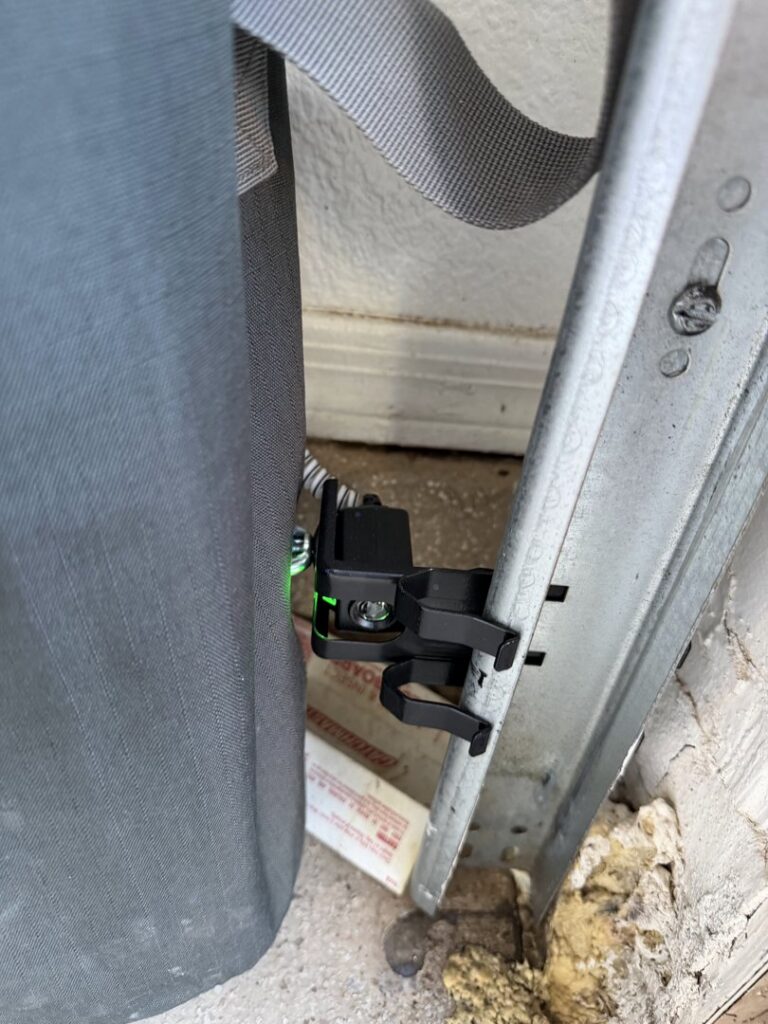 Close-up of a garage door safety sensor installation or repair by Calavera Garage Doors in Mesa, AZ