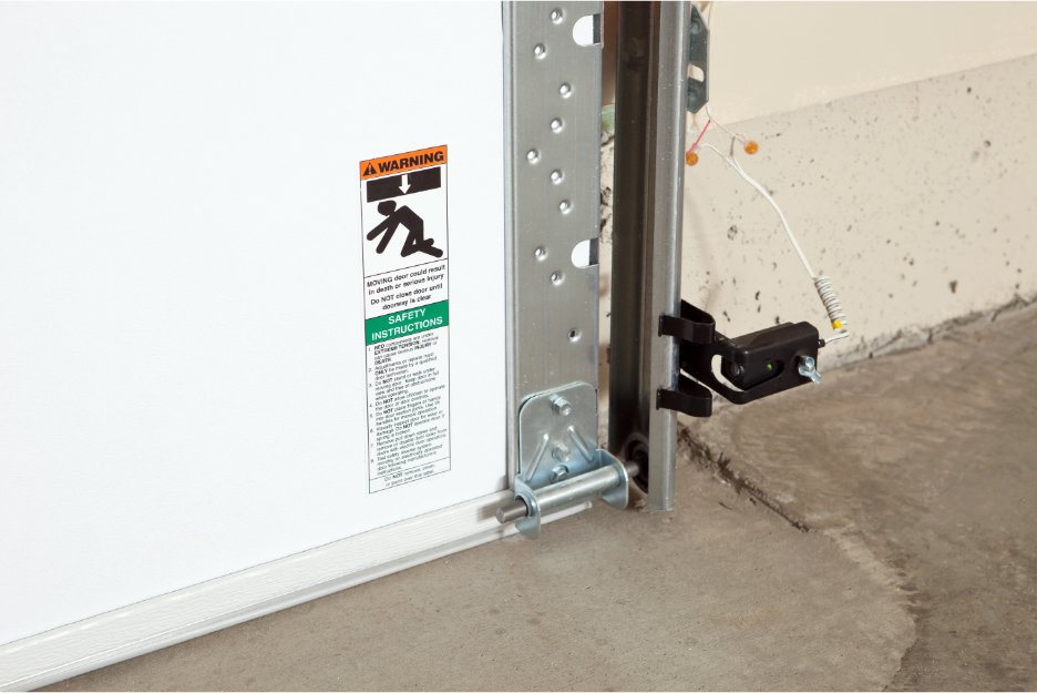 Close-up of a garage door safety sensor and track, indicating installation or maintenance by Iconic Garage Door Service in Queen Creek, AZ.