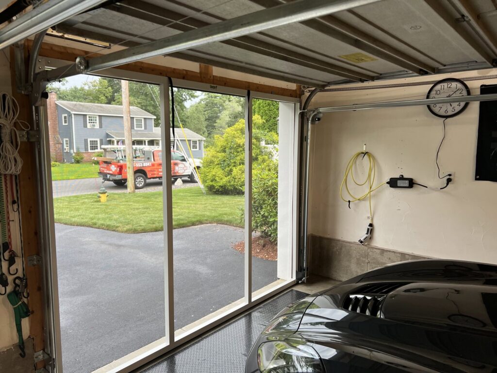 An interior view of a garage showing a screen door system installed by PM Garage Door in Hudson, NH.