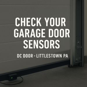 A close-up view of a garage door safety sensor, highlighting maintenance services by DC Door LLC in Littlestown, PA.
