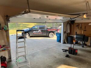 Garage door service in progress with Lenny's Garage Door truck visible outside in Louisville, KY.