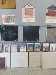 A showroom display featuring various garage door samples, color swatches, and brochures at B's Quality Door, Inc. in Enid, OK.