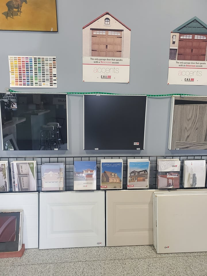 A showroom display featuring various garage door samples, color swatches, and brochures at B's Quality Door, Inc. in Enid, OK.