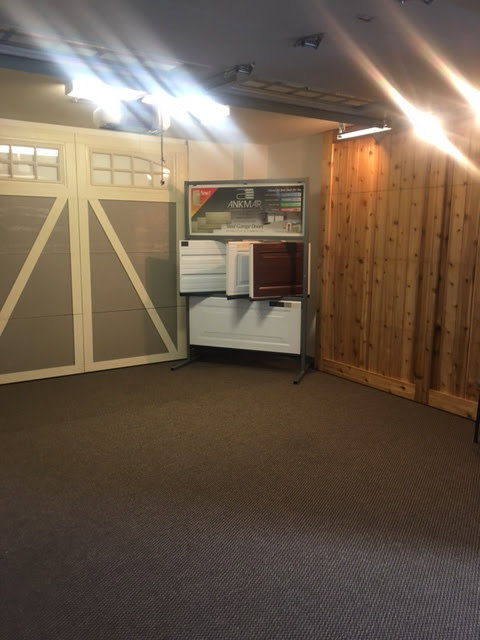 A showroom display featuring various garage door styles and samples at Greeley garage door repair in Greeley, CO.
