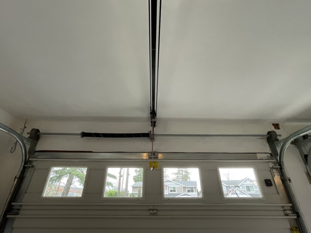 A close-up of a garage door spring and track mechanism, expertly serviced by Rainier Garage Door in Bellevue, WA.