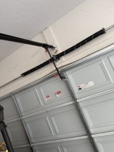Close-up of a garage door spring and track, indicating repair or maintenance work by Sonoran Garage Doors in Mesa, AZ