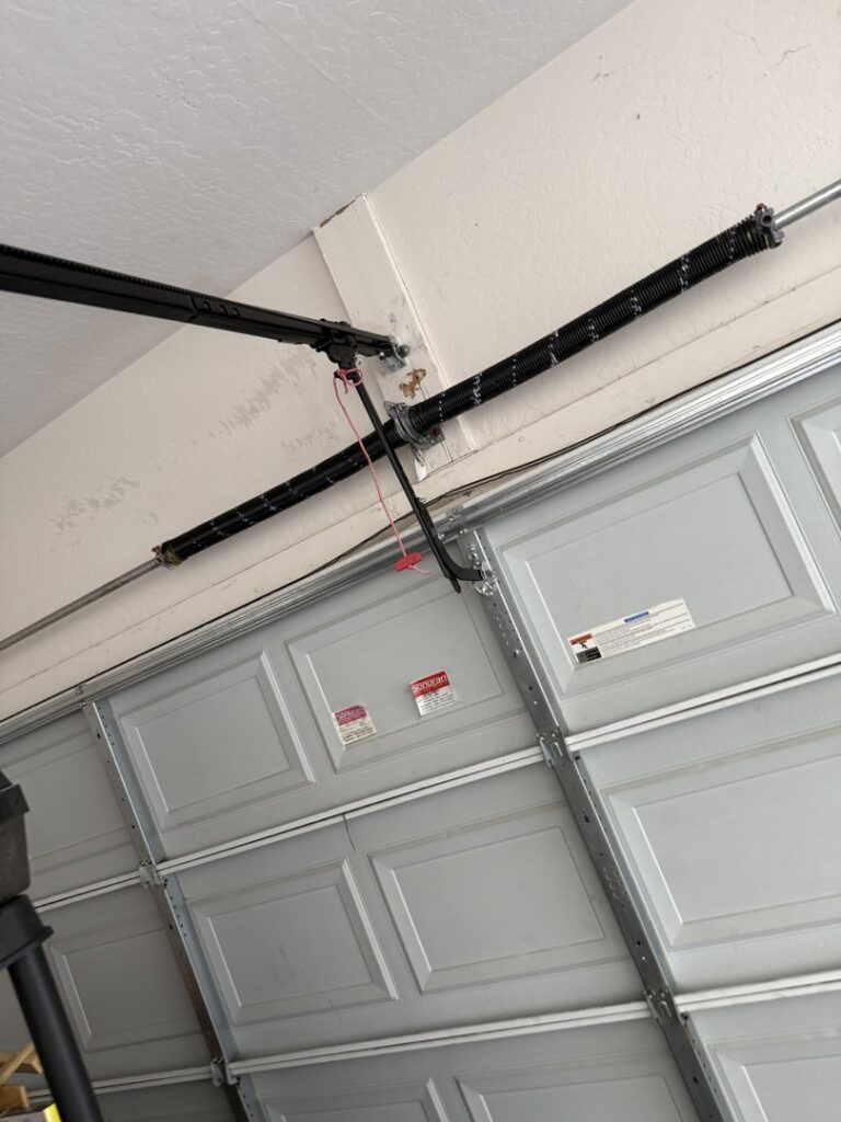 Close-up of a garage door spring and track, indicating repair or maintenance work by Sonoran Garage Doors in Mesa, AZ
