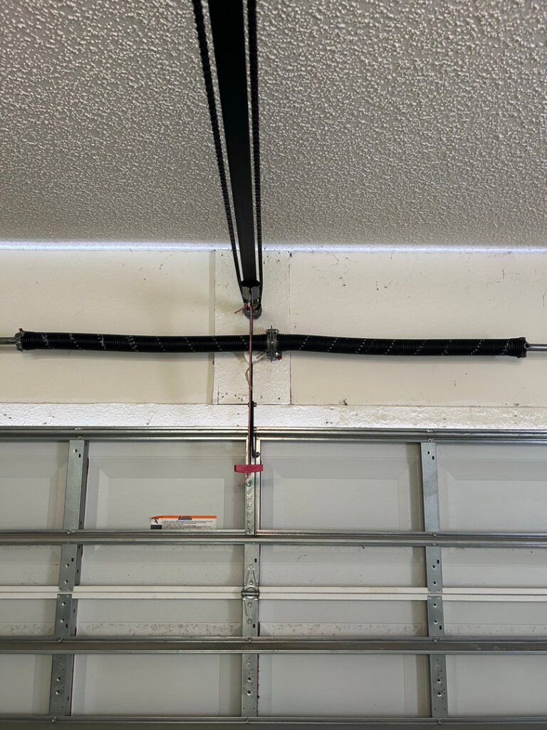 Interior view of garage door springs and tracks, showing components serviced by Chase Door Systems in Summerville, SC.