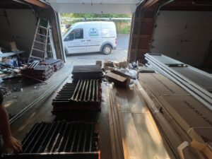 Garage door springs and panels inside a garage with an AAA Garage Door Services van outside in Renton, WA