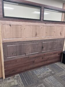 A showroom display showcasing various garage door styles, colors, and window options from Pham Garage Door Service & Repair in Arvada, CO.