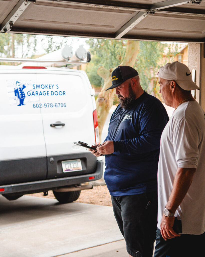 A garage door technician from Smokey's Garage Door Company consulting with a customer in Glendale, AZ.