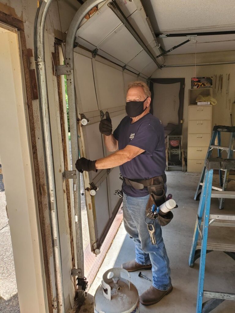 A garage door technician giving a thumbs up during a job by Garage Door Specialists Of Oklahoma Inc. in Oklahoma City, OK