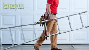 A garage door technician carrying a ladder, ready for service or installation by Element Garage Door Repair Of Portland, OR