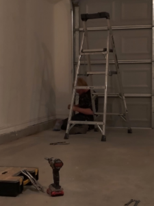 A garage door technician working on-site with tools for Zee's Garage Doors in Oklahoma City, OK.