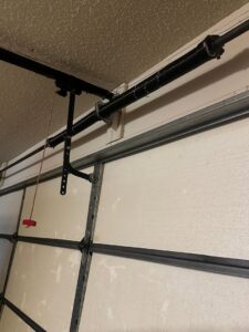 Close-up of a garage door torsion spring and track system, a common repair or installation component by Central Garage Door Repair LLC in Glendale, AZ.