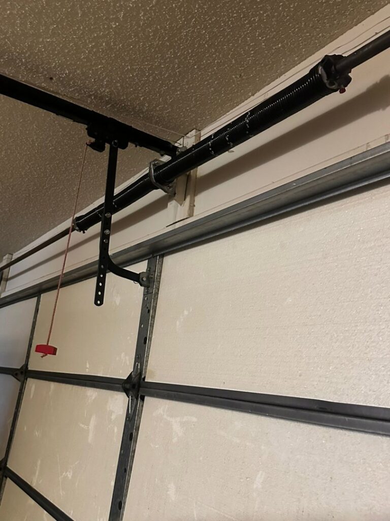 Close-up of a garage door torsion spring and track system, a common repair or installation component by Central Garage Door Repair LLC in Glendale, AZ.