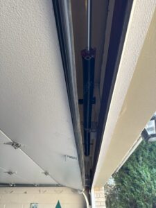 Close-up of a garage door torsion spring and cable system, indicating repair or installation by BSD Garage Door in Naperville, IL