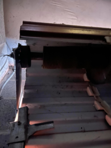 Close-up view of a garage door torsion spring and track system, indicating repair work by DOOR TECHS in Salem, OR.