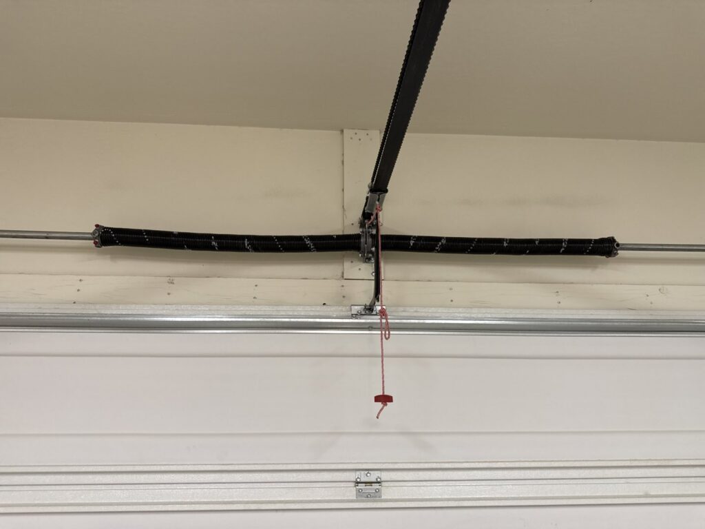 A close-up of a garage door torsion spring system, ready for repair or replacement by MGG Garage Door Service in San Tan Valley, AZ