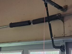 Close-up of garage door torsion springs and opener rail, indicating repair or installation by The Birmingham Man Garage Doors in Birmingham, AL.