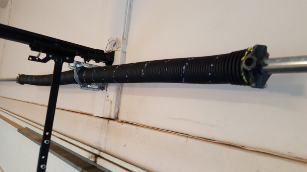 A close-up view of a garage door torsion spring, indicating replacement or repair work by Az Garage Door in Phoenix, AZ.