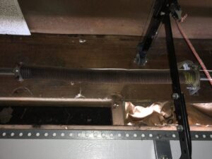 Close-up view of a garage door torsion spring system, a key component for repair and maintenance by OklaHome Overhead Doors in Tulsa, OK