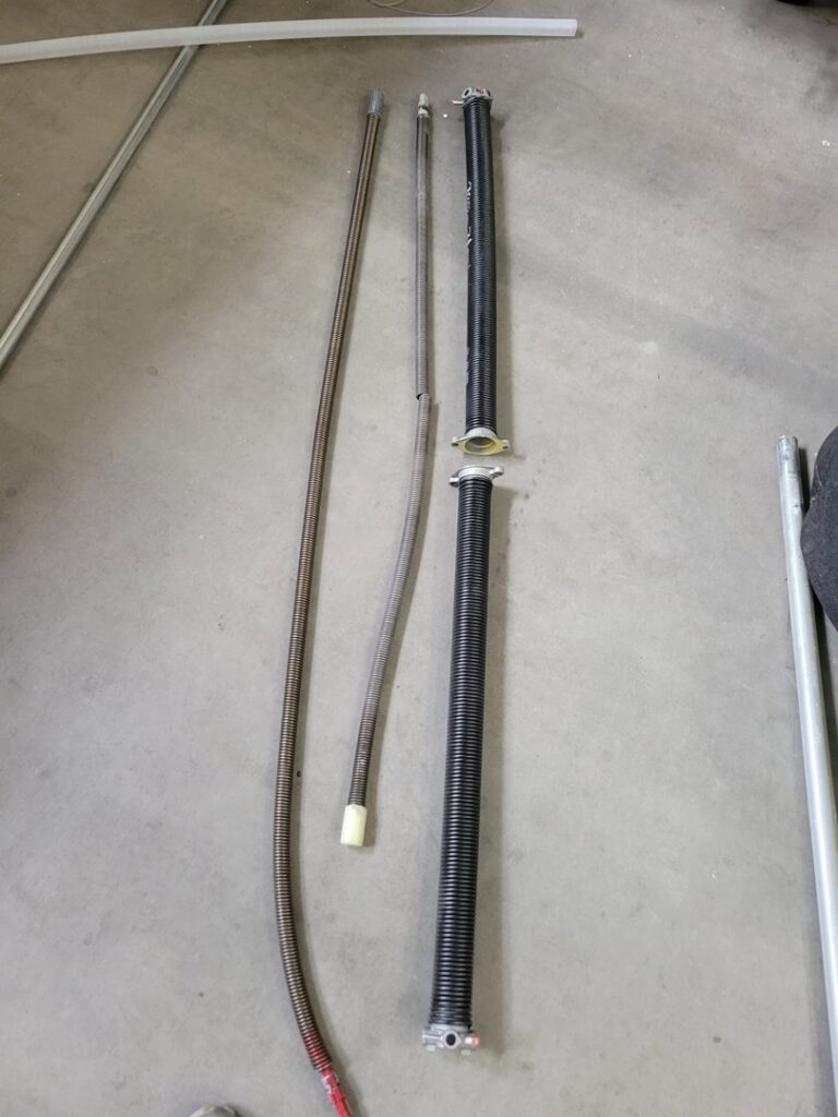 Various garage door torsion springs laid out for replacement or repair by Gryffin Garage Door in Chandler, AZ