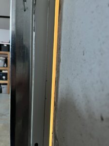 A close-up view of a garage door track and cable mechanism, indicating repair or installation work by SCI Door in Yakima, WA