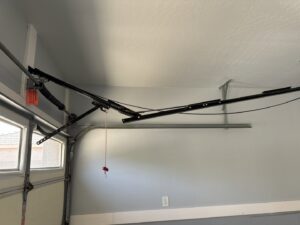 Interior view of garage door tracks, torsion springs, and opener rail system serviced by MGG Garage Door Service in San Tan Valley, AZ