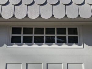 Close-up detail of the window section on a white garage door installed by Total Door Solutions in Yukon, OK