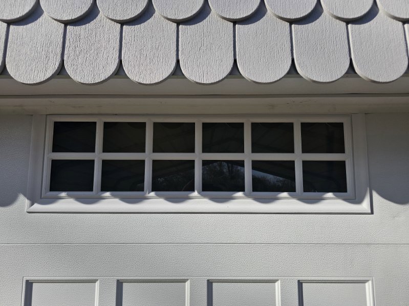 Close-up detail of the window section on a white garage door installed by Total Door Solutions in Yukon, OK