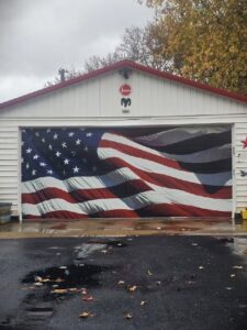 A garage door featuring a patriotic American flag design, installed by Steve's Overhead Door Company in Lafayette, IN.