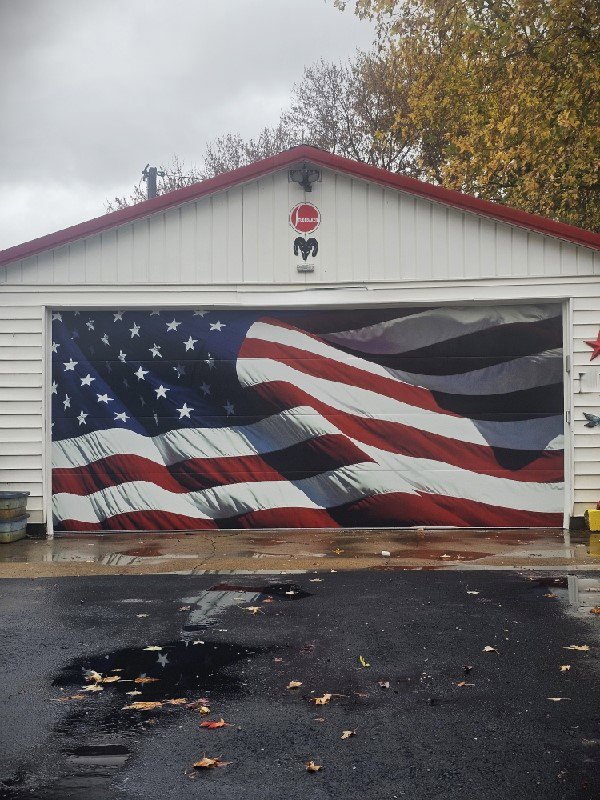 A garage door featuring a patriotic American flag design, installed by Steve's Overhead Door Company in Lafayette, IN.