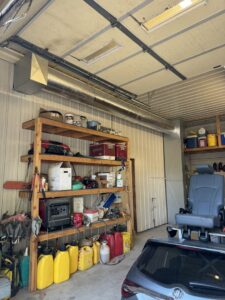 Exposed metal ductwork installed along the ceiling of a garage by Great Plains Heating & Air in Goddard, KS.