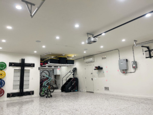 A clean garage interior showcasing new recessed lighting, electrical panel, and conduit installed by Desert Sun Electrical in Mesa, AZ.