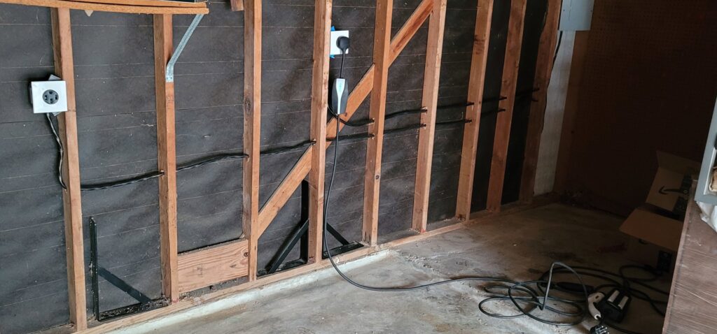 New electrical wiring and outlets, including an EV charger, installed on a garage wall by Ponce Electric in Houston, TX