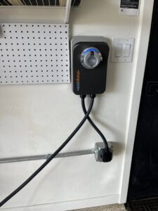 An EV charging station installed in a garage with visible conduit by HomeRun Electric LLC in Arlington, TX