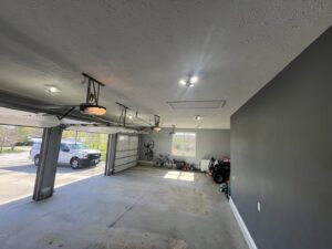 Garage interior with new ceiling lighting and garage door openers installed by Powered Electrical & Lighting Services LLC in Springfield, MO.