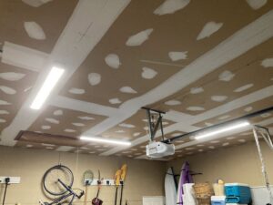 Garage with bright fluorescent strip lights and a garage door opener electrical connection by CLB Electrical LLC in Townsend, DE.